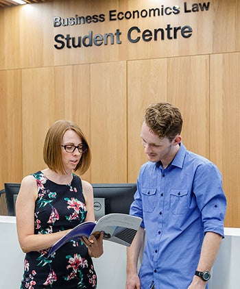 Staff and student lloking at some papers in the BEL Student Centre 